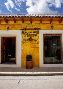 żółty budynek z znakiem na boku w obiekcie Hotel Posada Primavera w mieście San Cristóbal de Las Casas