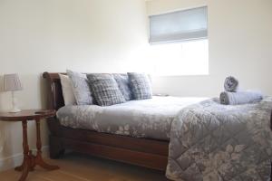 a bedroom with a bed and a window and a table at Staddlestones Broadway in Broadway