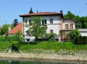 ein Haus auf einem Hügel neben einem Wasserkörper in der Unterkunft Apartment Soul in Ljubljana