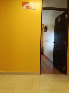 a hallway with a yellow wall and a black door at The Oruro Inn in Oruro
