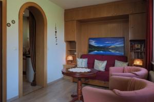 a living room with a red couch and a table at Gästehaus Kratzer in Virgen