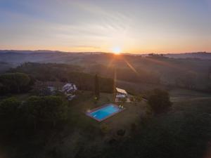 an aerial view of a house with a swimming pool at sunset at Villa Talciona in Poggibonsi