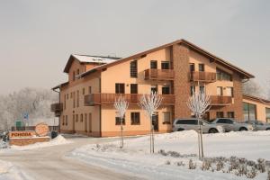 a apartment building in the snow with cars parked at Sportpenzion Pohoda in Pilsen