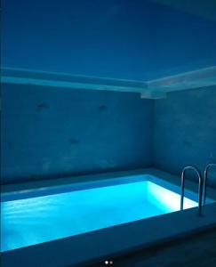 クラスノダールにあるОтель-сауна Messalinaの青い照明付きのバスタブが備わる客室です。