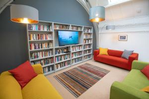 a library with two couches and a tv and books at The Five Turrets in Selkirk