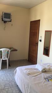 a bedroom with a bed and a tv on the wall at Hotel Ondas do Mar in Salinópolis