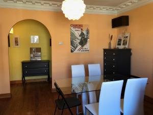 uma sala de jantar com uma mesa de vidro e cadeiras brancas em Puerta Del Carmen em Zaragoza