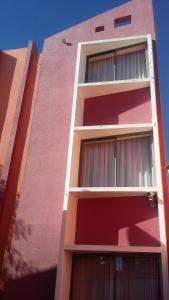 a pink building with windows on the side of it at Hotel Don Alfredo in Calama