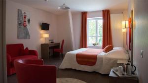 a hotel room with a bed and a red chair at Logis Hôtel De France in Domfront