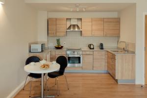
a kitchen with a table and chairs in it at PREMIER SUITES PLUS Glasgow George Square in Glasgow
