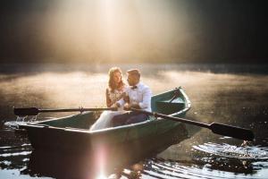 a bride and groom in a boat on the water at Pensiunea Claudia in Beliş