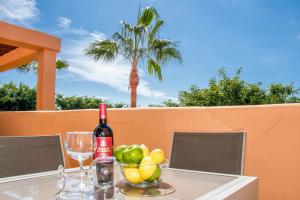 マルベーリャにあるFREE One Bedroom Retreat in Elviriaのワイン1本とフルーツ1杯を用意したテーブル