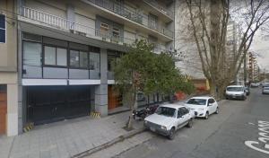 Dos coches aparcados delante de un edificio en Depto de 2 ambientes zona Guemes, en Mar del Plata