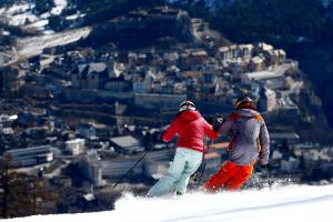 two people skiing down a snow covered mountain at Relais de la Guisane in Briançon