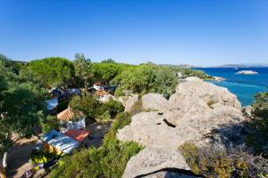 a group of large rocks on a beach next to the water at Camping Baia Saraceno in Palau