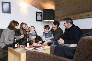 un gruppo di persone sedute attorno a un tavolo che mangiano cibo di CGH Résidences & Spas l'Orée des Neiges a Landry Altre 17 foto