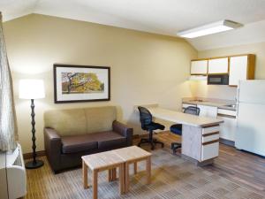 a living room with a couch and a desk and a kitchen at Extended Stay America Suites - Louisville - Alliant Avenue in Louisville
