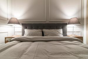 a bedroom with a large bed with two lamps at LuxApart Kalisz V.I.P in Kalisz