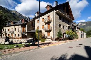a large stone building on the side of a street at Inmocyma Abetal grandes vistas, con piscina-Linsoles- Benasque in Benasque