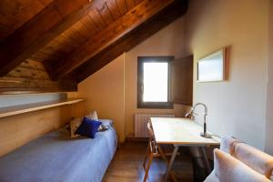 a bedroom with a bed and a desk and a window at Inmocyma Abetal grandes vistas, con piscina-Linsoles- Benasque in Benasque +37 photos