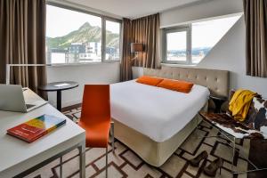 a hotel room with a bed and a desk with a laptop at Adagio Grenoble Centre in Grenoble