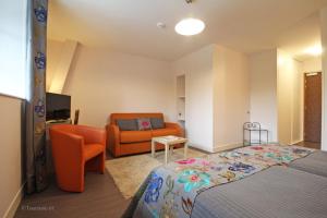 a bedroom with a bed and a couch at Logis Hôtel De France in Domfront