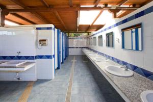 a bathroom with a row of sinks and toilets at Camping Baia Saraceno in Palau +91 photos