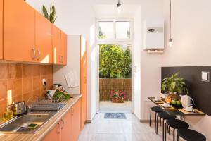 una cucina con armadi arancioni e tavolo con sedie di Cracow Best Location Apartment with Garden by Cozyplace a Cracovia