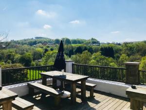 a picnic table with an umbrella on a deck at The Sycamore Inn in Birch Vale