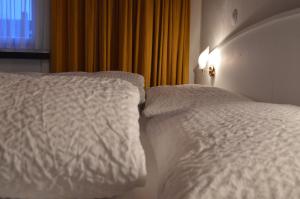 Postel nebo postele na pokoji v ubytování Hotel Garni Rösslipost
