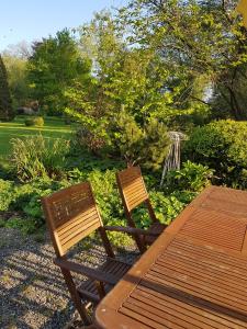 2 sillas de madera sentadas junto a una mesa de madera en Logis Hôtel De France, en Domfront