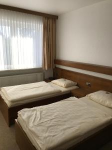 a hotel room with two beds and a window at Hotel Esinger Hof garni in Tornesch