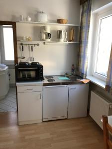 eine Küche mit Mikrowelle und Spüle in der Unterkunft Hotel Esinger Hof garni in Tornesch