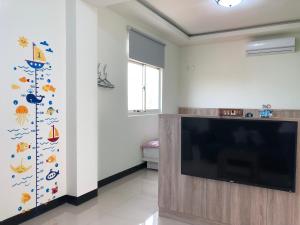 Una sala de estar con un televisor de pantalla plana grande. en Country House Homestay, en Jinning