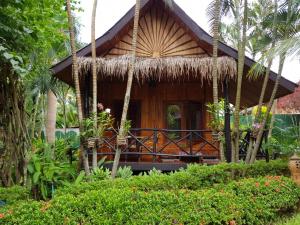 a resort cabin with a thatched roof at Thongbay Guesthouse in Luang Prabang
