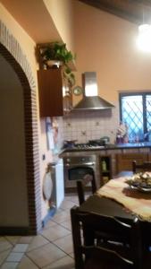 eine Küche mit einem Tisch und einem Herd Top-Backofen in der Unterkunft 34 Via Cillei in Mascalucia