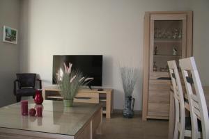 sala de estar con mesa y TV en Appt Hotel republique, en Lille