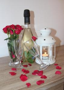 uma garrafa de vinho e dois copos e flores numa mesa em B&B Poggio di Balestrino em Balestrino