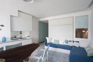 a living room with a blue couch and a kitchen at Vongola in Portovenere