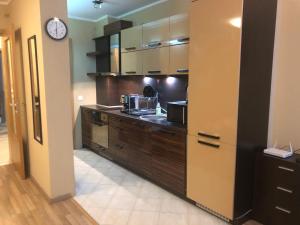 a kitchen with wooden cabinets and a clock on the wall at Rakovski Apartment GN / FREE GARAGE in Sofia