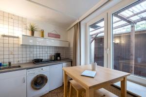 eine Küche mit einer Waschmaschine und einem Holztisch in der Unterkunft Garden Apartment in Köln
