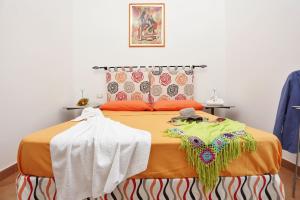 a bedroom with a bed with an orange bedspread at Capo d'Orlando Apartments - Sabbia in Capo dʼOrlando