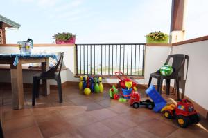 卡普多蘭多的住宿－Capo d'Orlando Apartments - Sabbia，一间位于地板上并配有桌椅和玩具的客房