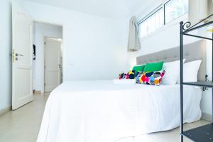 une chambre blanche avec un grand lit blanc dans l'établissement Lima waikiki beach, à Corralejo