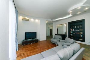 a living room with a couch and a tv at LUX near Maidan, Khreschutyk 3BR in Kyiv