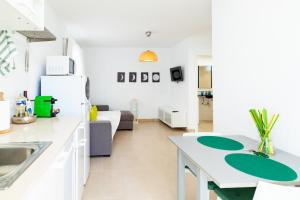 uma cozinha e sala de estar com um lavatório e um frigorífico em Lima waikiki beach em Corralejo