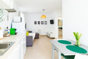 Il comprend une cuisine et un salon avec un évier et un réfrigérateur. dans l'établissement Lima waikiki beach, à Corralejo