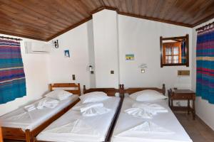 two twin beds in a room with a mirror at Pegasus Hotel in Pythagoreio