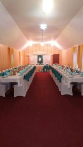un salón de banquetes con mesas blancas y sillas verdes en Hotel Tropicana, en Svitlovodsʼk