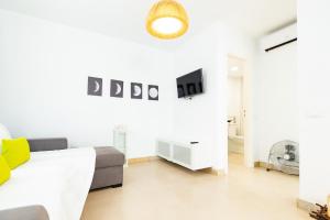 a white living room with a bed and a couch at Lima waikiki beach in Corralejo